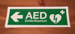 Defibrillaattori tarra vasemmalle